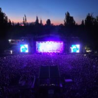 Nocny widok z drona na wypełnioną tłumem Letnią Scenę Progresji podczas jUWenaliów w Warszawie
