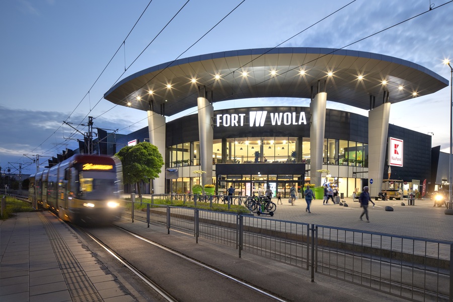 Centrum handlowe Fort Wola nocą przy ulicy Połczyńskiej w Warszawie — tramwaj na pierwszym planie