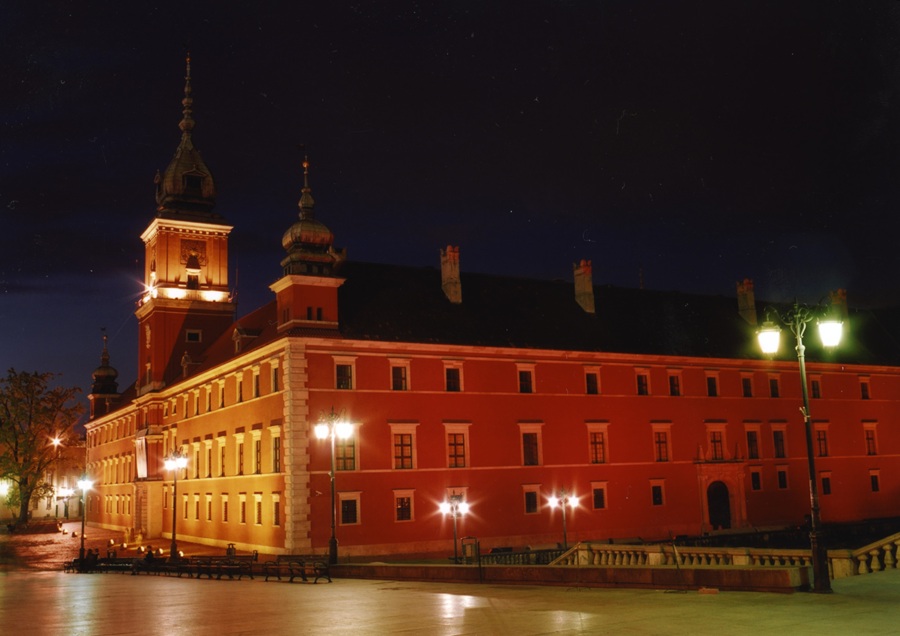 Zamek Królewski w Warszawie nocą oświetlony latarniami na Placu Zamkowym