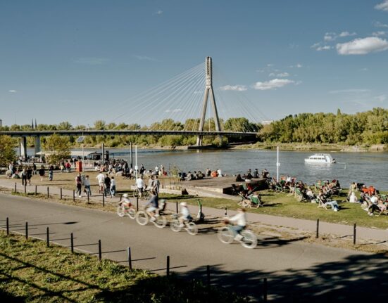 Warszawiacy na rowerach i leżakach na bulwarach Wisły w Warszawie przy Moście Świętokrzyskim latem