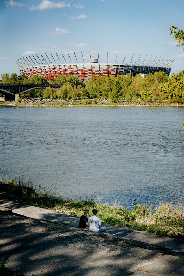 Para siedząca nad Wisłą z widokiem na Stadion Narodowy w Warszawie