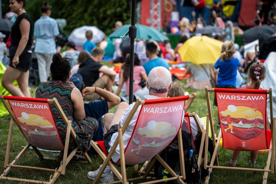 Rodziny z dziećmi odpoczywające na leżakach podczas Warszawskiego Kocykowania w parku - piknik plenerowy w Warszawie