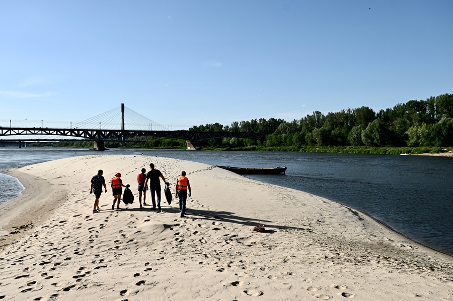 Grupa uczestników Wodniackich porządków sprzątająca plażę nad Wisłą
