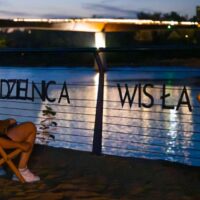 Napis Dzielnica Wisła nad rzeką w Warszawie wieczorem